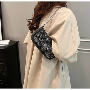 Close-up of Y2K rhinestone denim underarm bag with silver chain strap and sparkling finish