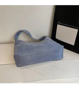 Detail der blauen Denim-Tragetasche mit Köperstruktur und breitem Schultergurt