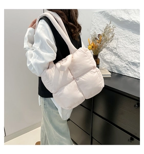 Nahaufnahme einer großen gesteppten Puffer-Tasche in Beige mit weicher Polsterung