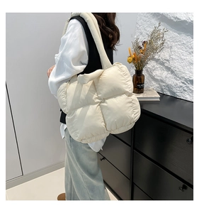 Detail der cremeweißen gesteppten Puffer-Tasche mit großem Karomuster und weicher Textur
