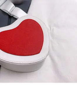 Detailed macro view of red and white heart-shaped bag with Saffiano textured surface