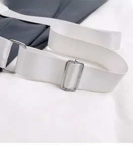 Detail of silver metal buckle and white nylon strap on dark grey crossbody bag