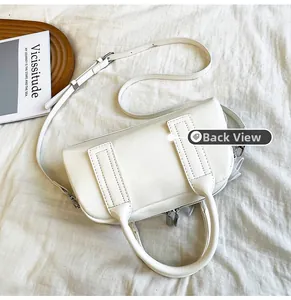 Vue arrière détaillée du sac Boston blanc en cuir vintage sur un plateau en bois