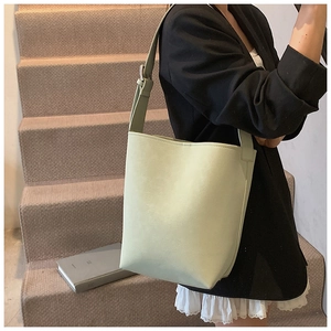 Detailansicht der minzgrünen Leder-Eimertasche mit verstellbarem Gurt an einem Model