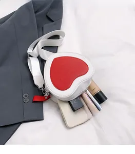 Detail view of heart-shaped crossbody bag showing internal space for phone and makeup