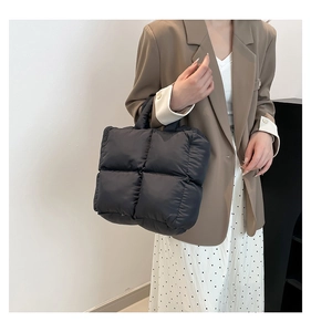 Modische schwarze gesteppte Puffy-Tasche kombiniert mit braunem Blazer für den Alltag