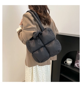 Detail einer schwarzen Stepptasche mit weicher Polsterung und Stoffstruktur