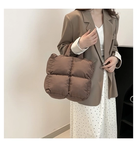 Nahaufnahme der braunen gesteppten Puffer-Tasche aus Nylon mit weicher Daunenoptik