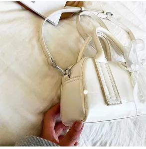 Détail du sac Boston blanc avec chaîne en perles, nœud en tulle et bandoulière amovible