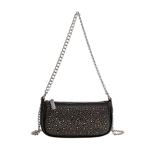 Sac baguette noir rétro avec rivets argentés et bandoulière chaîne sur fond blanc