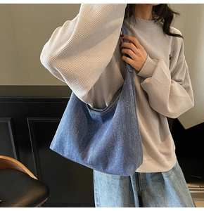 Detailansicht der großen blauen Denim-Tragetasche getragen von einem Modell im Freizeitstil