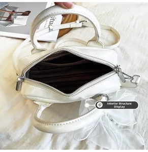 Structure intérieure du sac Boston blanc montrant la doublure rayée et la poche