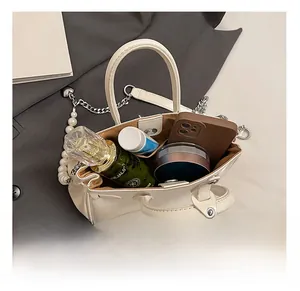 Interior view of off-white leather bucket bag showing capacity for phone and perfume