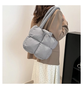Detail der grauen gesteppten Puffer-Tasche an der Schulter mit weicher Textur