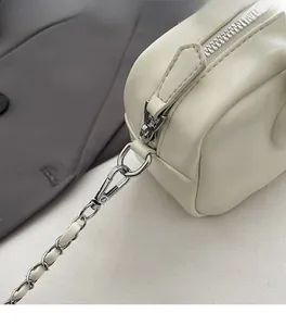 Detail of off-white leather bowling bag with silver hardware and chain strap