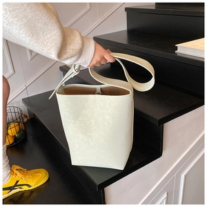 Detailansicht der cremefarbenen Beuteltasche mit Litschi-Struktur und braunem Innenfutter