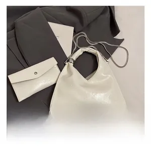Detailed view of white glossy leather tote with chain and matching envelope clutch set