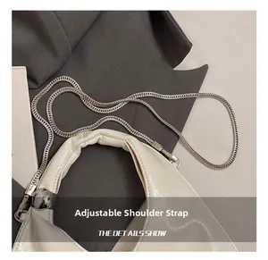 Detail view of adjustable silver chain strap on glossy white leather hobo shoulder bag