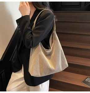 Detail shot of the large champagne gold metallic tote bag worn over the shoulder