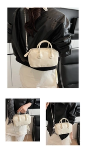 Close-up of cream-white bowling bag with metal chain strap and logo detailing
