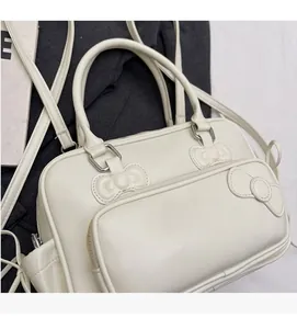 Detail of cream PU leather handbag featuring a decorative 3D stitched bow and metal zipper