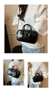 Detail of black patent leather bowling bag with metallic chain strap and top handles