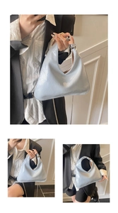 Detail of light blue asymmetric handbag with silver metal ball and chain strap