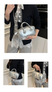 Close-up of metallic silver bowling bag with dual handles and elegant chain strap