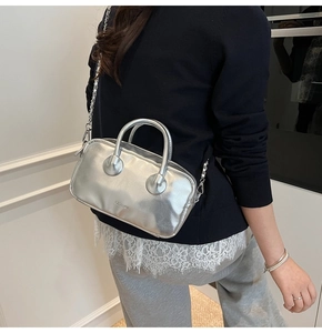 Model showing a silver metallic bowling bag with a chain strap and CLEANBOX logo