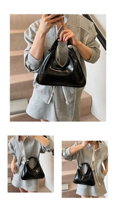 Detailed view of black patent leather triangle handbag with oversized silver sphere and chain