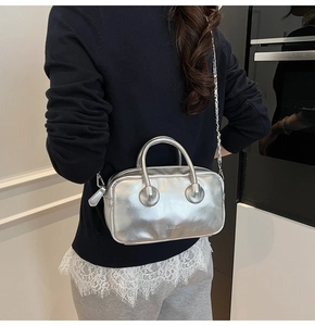 Silver metallic crossbody bag with chain strap shown on model for size and style reference