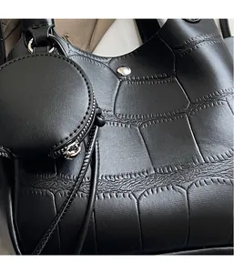 Détail d'un sac à main noir en cuir gaufré crocodile avec mini porte-monnaie rond