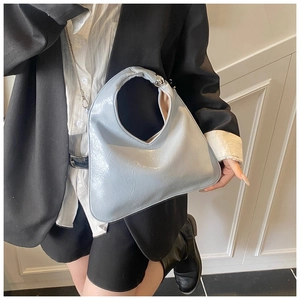 Detail of glossy patent leather tote bag with unique heart-shaped cutout handle design