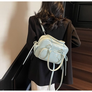 Detail of light green pillow handbag with drawstring accents and adjustable shoulder strap