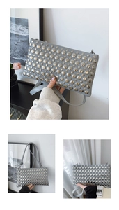 Detail of grey faux leather handbag with metallic silver stud rivets and a slim strap