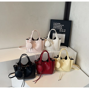 Détail de cinq sacs seaux gaufrés croco de différentes couleurs avec mini breloques assorties