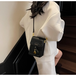 Detail showing the inner compartments of a black leather crossbody phone bag on a model