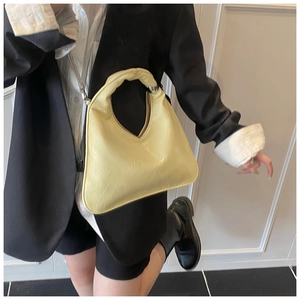 Dettaglio della borsa hobo color crema con manico spesso e anelli in argento