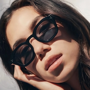 Chic black square frame sunglasses with metal rivets and dark lenses worn by a model