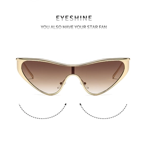Detail of metal cat-eye sunglasses featuring golden frames and brown gradient lenses