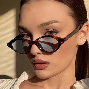 Vintage tortoiseshell cat-eye sunglasses with dark lenses and elegant shadow lighting