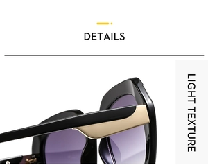 Close-up of stylish sunglasses featuring sleek black frame with golden metallic hinge detail