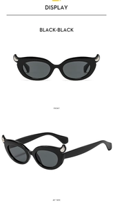 Front and side view of trendy cat eye sunglasses with black frames and wing detailing