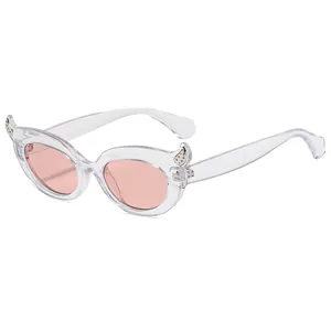 Fashionable cat eye sunglasses with clear frames, pink lenses and sparkling devil horn details
