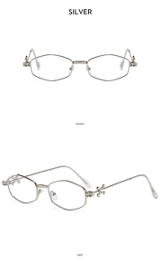 Detail view of silver polygonal sunglasses showing rhinestone cross and镂空 temples