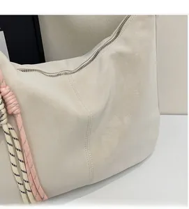 Detail shot of soft cream white faux leather tote bag with woven rope decoration