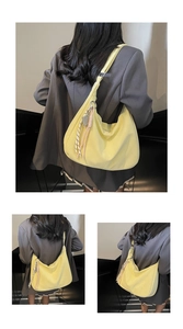 Detail of yellow hobo bag with braided rope charm and soft texture on a grey suit
