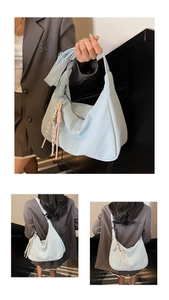 Macro detail of a soft light blue faux leather hobo tote bag with a woven knot charm