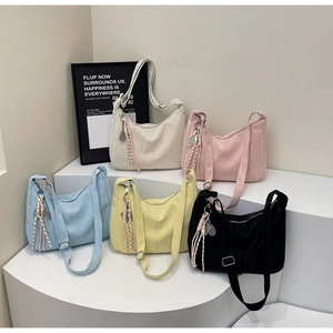 Detailed display of five colorful soft leather hobo bags with woven tassel charms