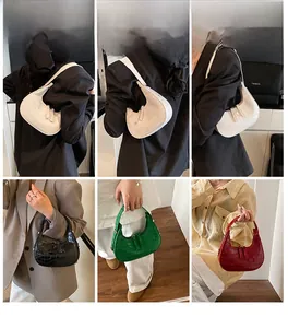 Dettaglio delle borse a mezzaluna con trama a coccodrillo in vari colori alla moda